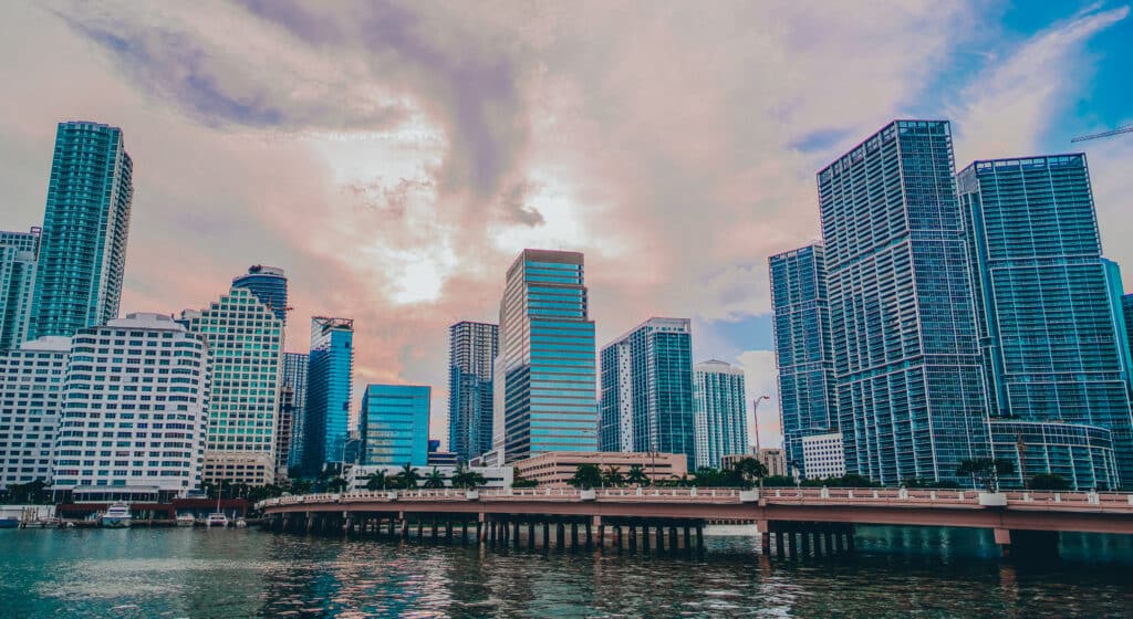 Modern waterfront skyline with high-rise buildings and luxury condominiums at sunset in a vibrant urban district, reflecting real estate investment potential.